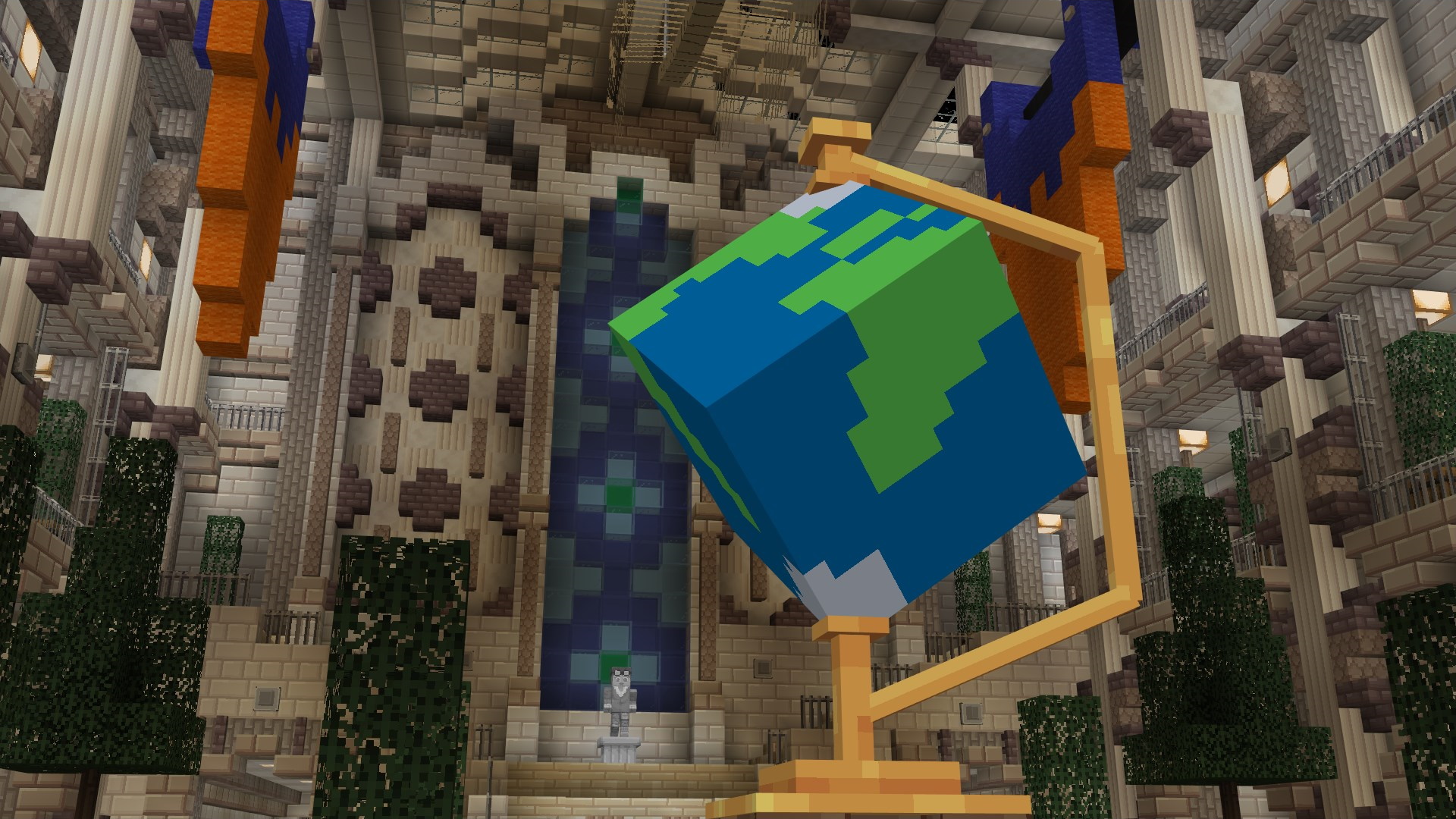 A screenshot within Minecraft of the globe from the museum lobby of Heist-Meisters. The globe is several metres tall. There are blue and orange banners hanging from the ceiling, and there are several trees on either side of the room. There is a staircase at the back of the room which leads up and to balconies on the left and right.